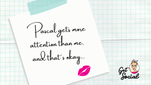 An image of a sticky note against a blue-checked notebook background taht reads "Pascal gets more attention than me, and that's okay". There's a pink lipstick kiss at the bottom of the note